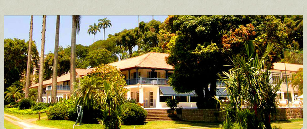 Casa-sede colonial do Gávea Golf and Country Club, cercada de jardins e palmeiras